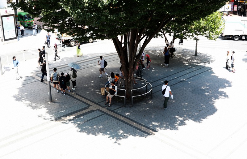 木陰で休む通行人ら＝JR新宿駅前で2025年8月5日午後0時23分、小出洋平撮影