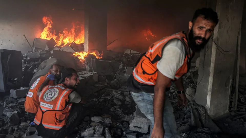 Palestinian civil defense try to extinguish a fire at a building hit by an Israeli strike in Gaza City in the central Gaza Strip, on July 2 amid the ongoing conflict between Israel and the Palestinian Hamas militant group. - Omar Al-Qattaa/AFP/Getty Images