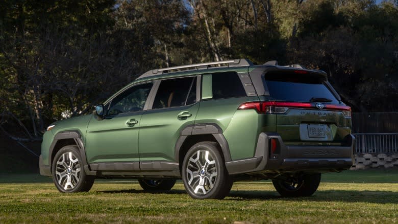 rear three-quarters shot of a green 2026 Outback parked on grass