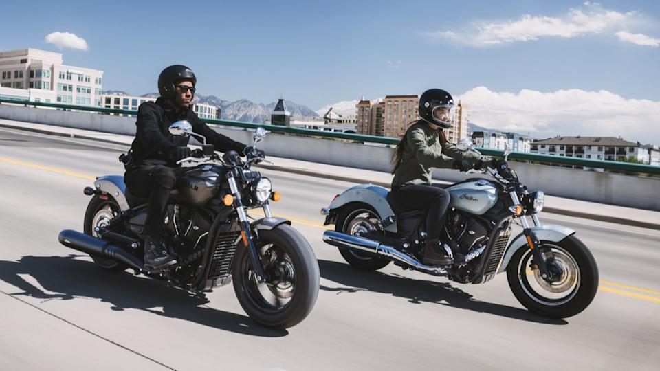 Two Indian Scout Sixty motorcycles on the road.