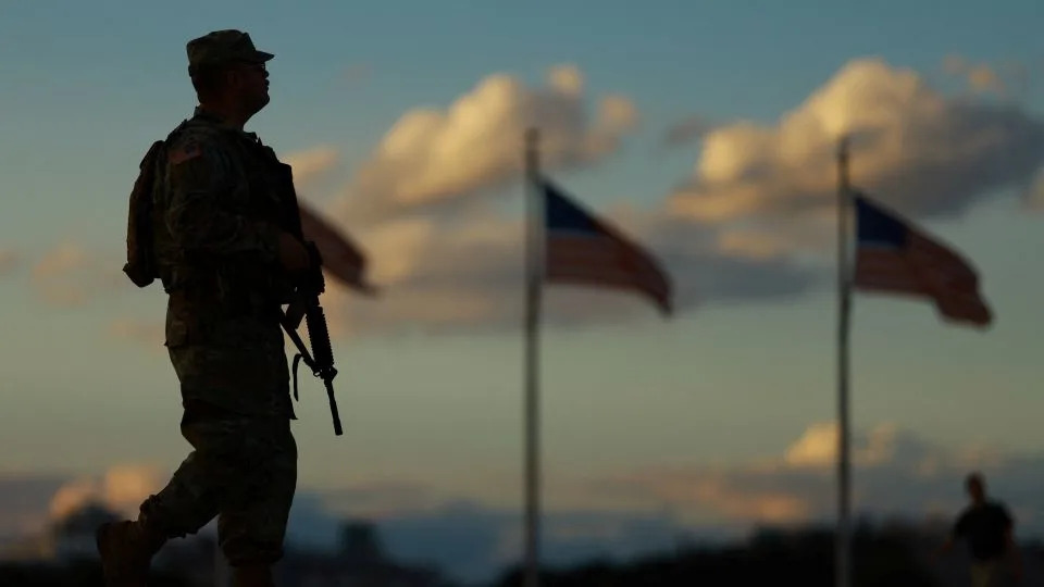 A member of the National Guard carries a firearm while patrolling the National Mall in Washington, DC, on Tuesday. - Jose Luis Gonzalez/Reuters