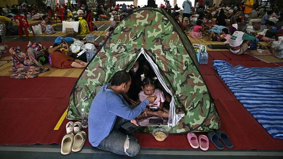 Thai evacuees eat breakfast as they take shelter in a gymnasium on the grounds of Surindra Rajabhat University in the border province of Surin on July 25. - Lillian Sunwanrumpha/AFP/Getty Images