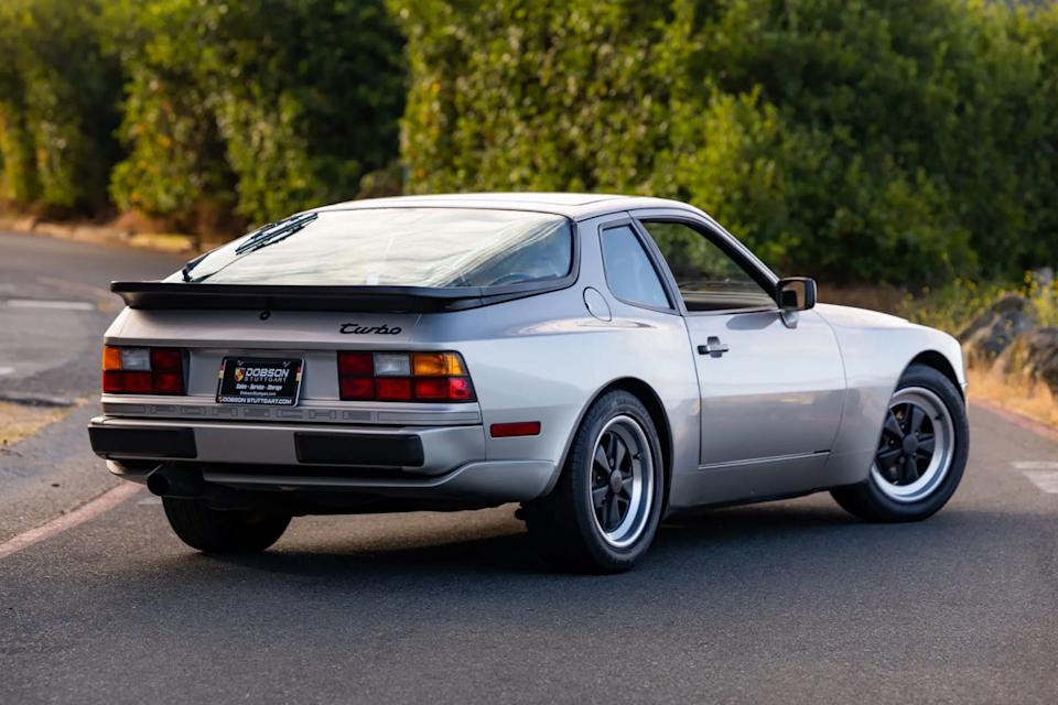 rear left angle of silver coupe showing taillights, black spoiler, and rear badging.
