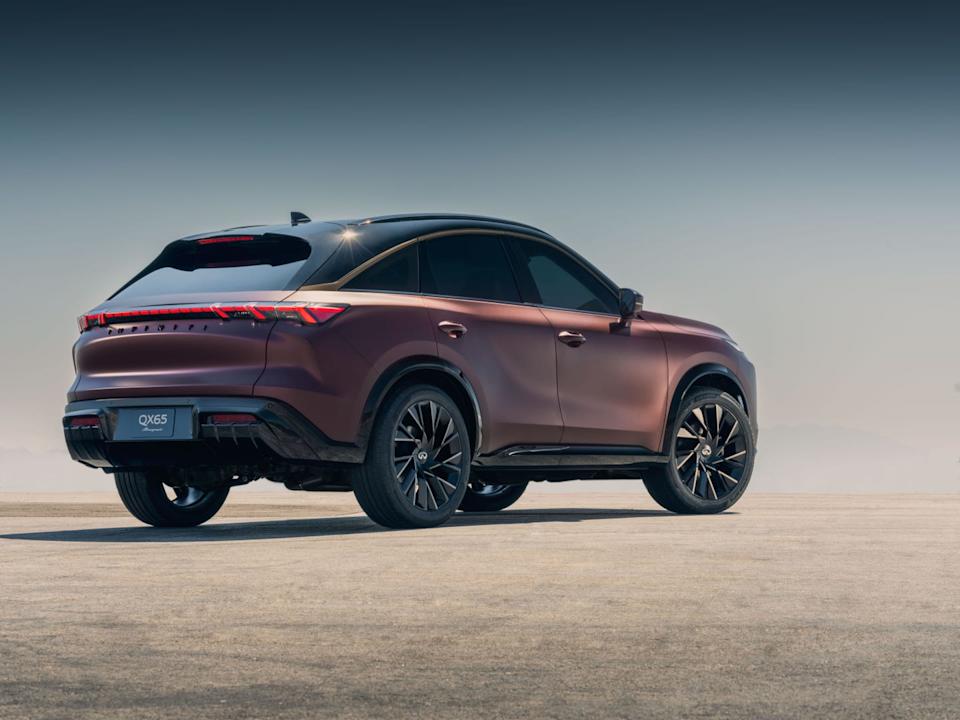 rear three quarter view of bronze suv parked on concrete surface with mountains in background.