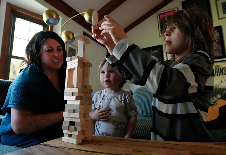 Michaela Schnetzer plays a game with her sons Ryatt, 2, and Brady, 10, at their home on Tuesday, June 24, 2025 in White House, Tenn. Brady will be a fifth grader at White House Intermediate School in the fall.