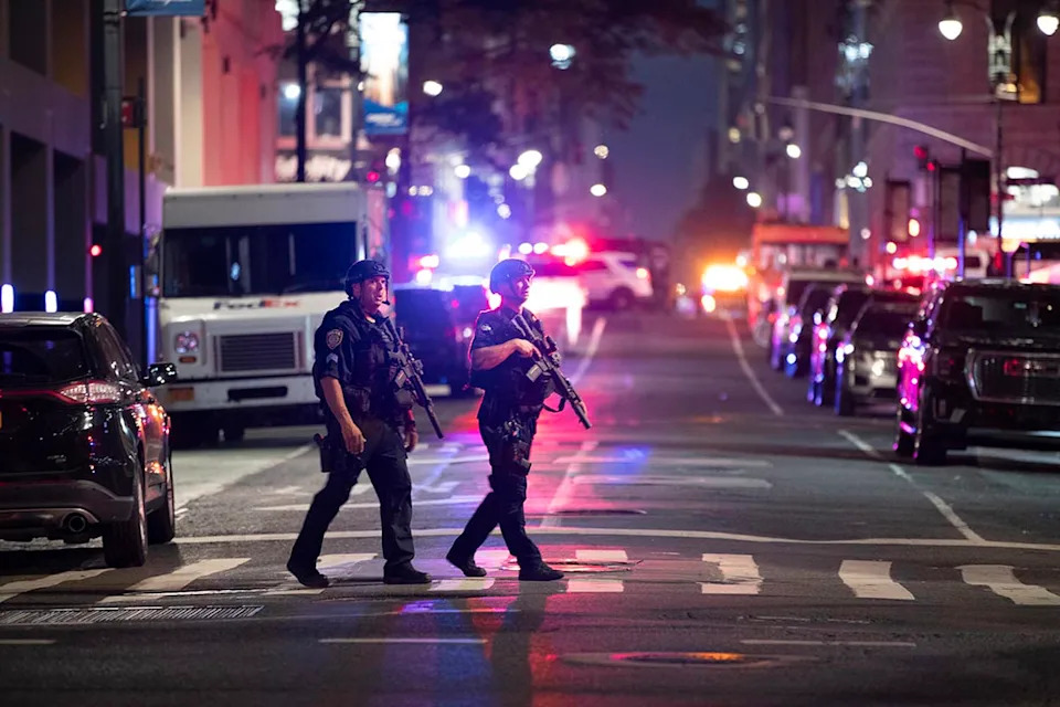 Police officers gather in a street as they respond to a shooting incident in the Midtown Manhattan neighborhood of New York on July 28, 2025 in New York City.  (Liao Pan / AP)