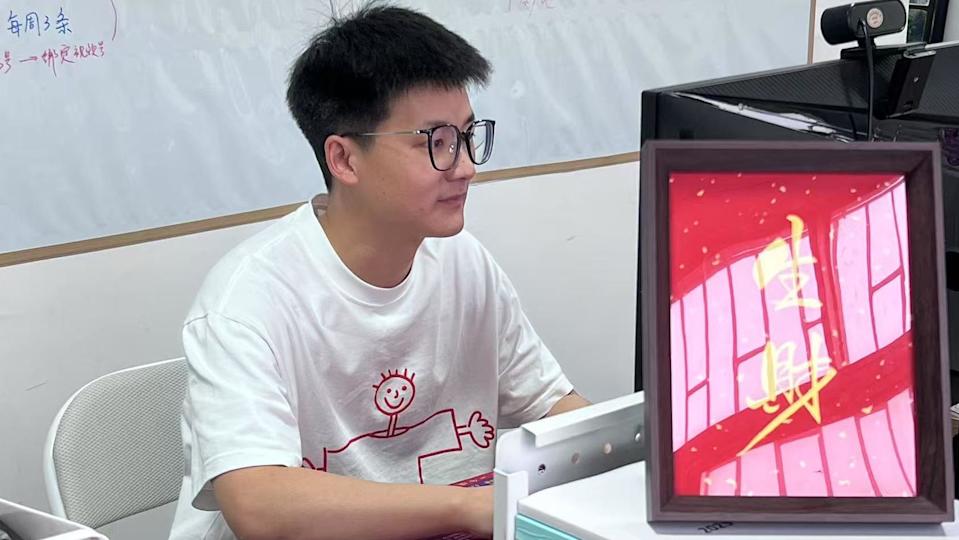 Feiyu, un joven de 30 años que es dueño de la empresa Pretend To Work Company, mira la pantalla de su computadora