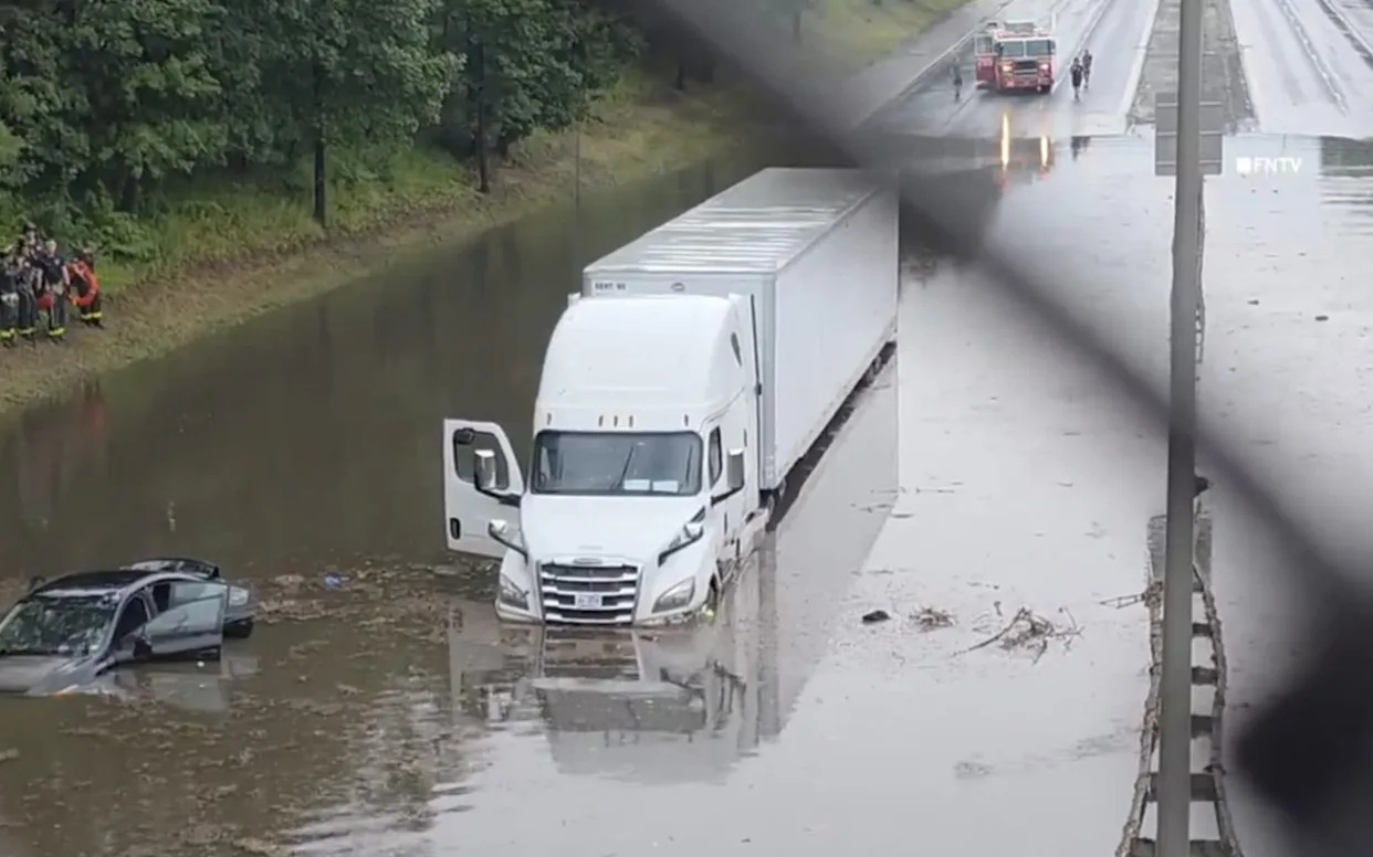 A lorry is submerged in flood water as heavy rain falls in New York
