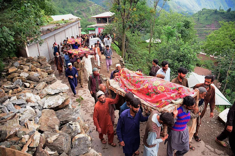  Mourners carry the coffins of flood-affected victims after flash floods in Naryean Behaak village, some 36 kilometers north of Muzaffarabad, the capital of Pakistan-administered Kashmir. / Credit: SAJJAD QAYYUM/AFP via Getty Images