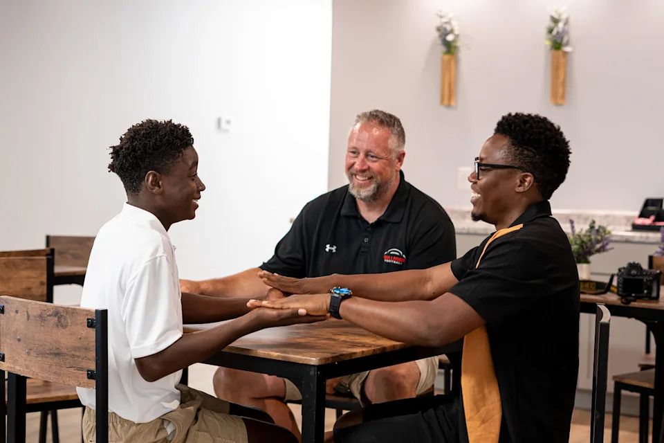 Francion Schafer, 13, thumb wrestles with March Rocher and his father, Andy Schafer. (Cydni Elledge for NBC News)