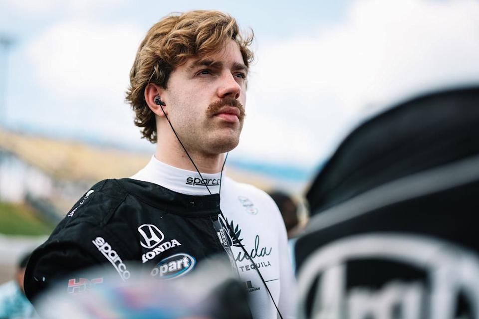 Racing driver preparing for a race wearing a racing suit