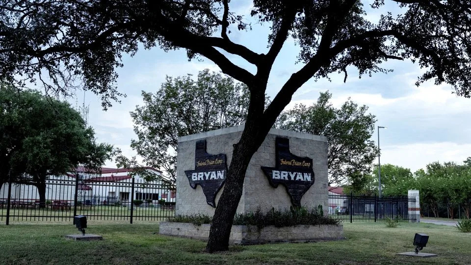 A tree shades the entrance to the Federal Prison Camp in Bryan, Texas, on Friday. - Adrees Latif/Reuters