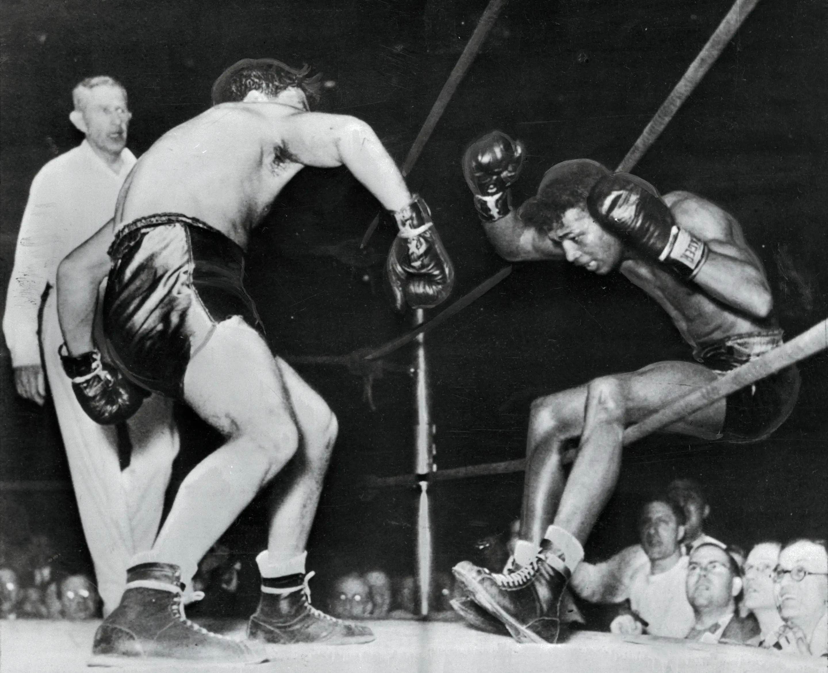(Original Caption) Victorious in 129 successive fights, including 40 as a pro, Ray Robinson falls through the ropes of a Detroit ring, under the impact of Jake LaMotta's fists. Robinson got back in the ring, but lost the decision in ten rounds.