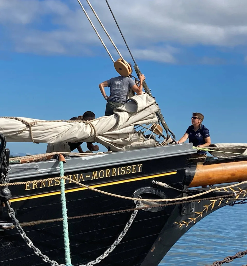 Tiffany Krihwan, captain of the SSV Ernestina Morrissey, talks to crew members near the mast of her tall ship during Tall Ships Erie 2025 on Aug. 22, 2025.