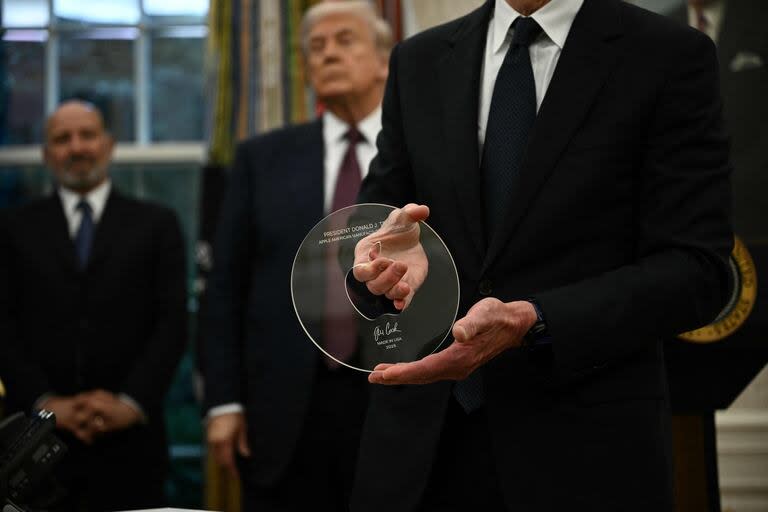 El CEO de Apple, Tim Cook, muestra un recuerdo en el Despacho Oval de la Casa Blanca en Washington, DC, el 6 de agosto de 2025