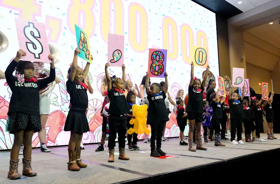 Aug. 12, 2025; Tuscaloosa, AL, USA; Children from the Creative Child Development Learning Center lift up the goal of $4.8 million for the United Way’s Campaign Kickoff at the Bryant Conference Center.
