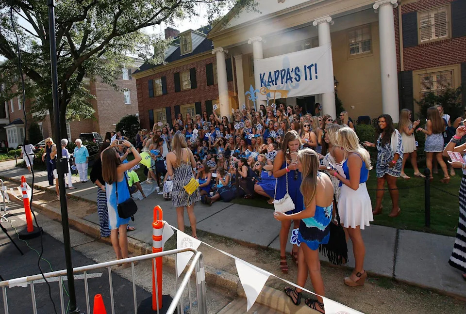 Current members of Kappa Kappa Gamma mingle in front of their sorority house as photographers with Zaps take pictures on Bid Day along Colonial Drive at the University of Alabama in Tuscaloosa, Ala. on Saturday Aug. 16, 2014. Approximately 2,300 girls participated in the University of Alabama's fall recruitment.  staff photo | Erin Nelson