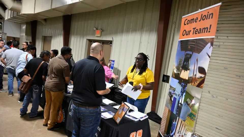 Personas que buscan empleo conversan con representantes de las Escuelas Públicas del Condado de Orange que buscan cubrir vacantes durante una feria de empleo en el Recinto Ferial del Condado de Orange, el jueves 10 de julio en Orlando, Florida. - Phelan M. Ebenhack/AP