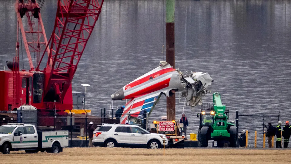 A crane offloads a piece of wreckage