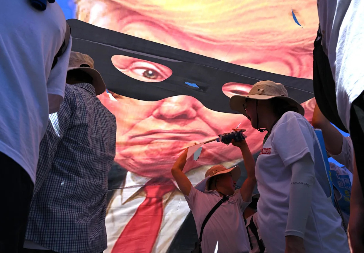 <span>South Korean protesters tear a big banner showing a caricature of Donald Trump as a robber during a rally against Trump's tariff policy near the US embassy in Seoul on 27 July 2025.</span><span>Photograph: Jung Yeon-Je/AFP/Getty Images</span>