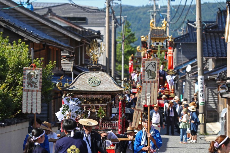 2台の曳山がみこしの後に続き黒島のまちなかを進む=石川県輪島市で2025年8月18日午後3時4分、岩本一希撮影