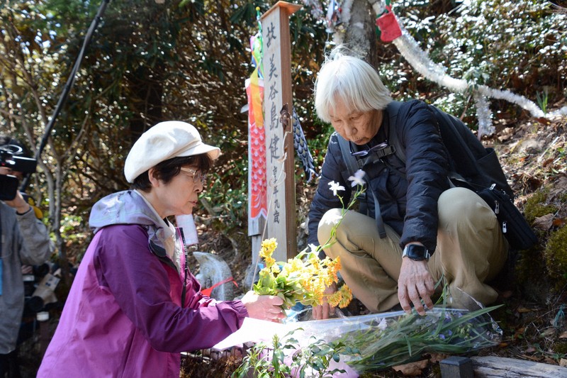 健さんの銘標に花を手向ける美谷島邦子さん（左）＝群馬県上野村で2025年4月29日午前11時45分、加藤栄撮影