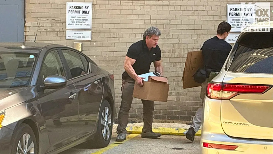 An FBI agent carries a box after a search at John Bolton’s D.C. office, Aug. 22, 2025.