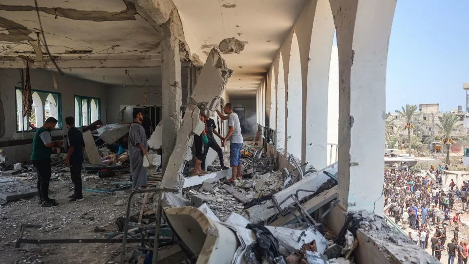 Palestinians clamber over the rubble, after Israel forces attacked the Khadija school, central Gaza, on July 27, 2024. A leading rights group warned that Israel has damaged or destroyed "virtually all" of Gaza's schools. - Eyad Baba/AFP/Getty Images