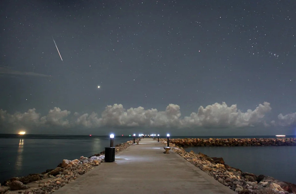 A Perseid meteor, seen at top left, streaks in 2009 through the sky over Florida.