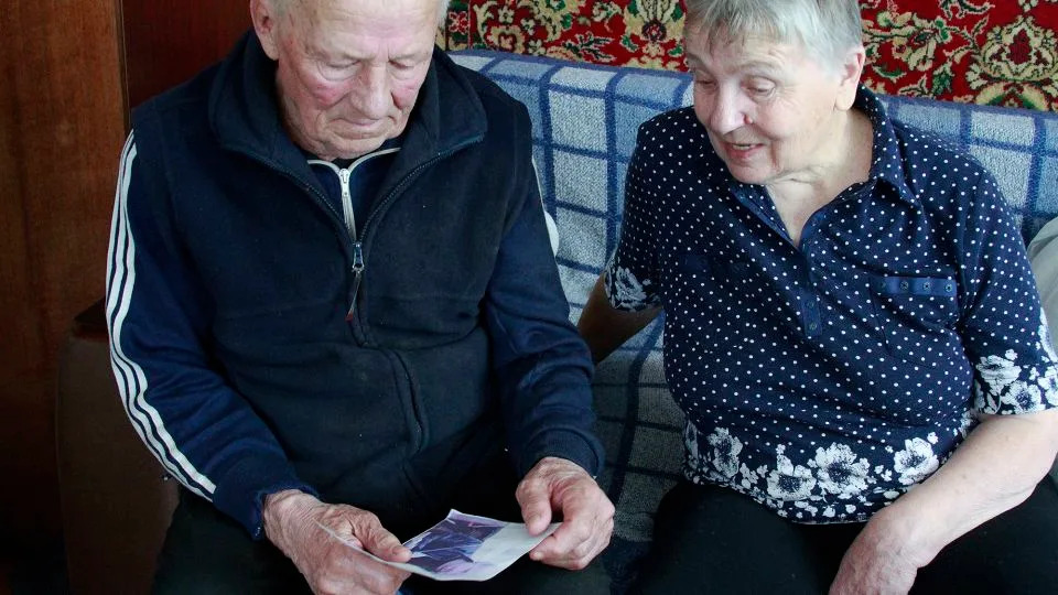 Halyna and Vasyl Khyliuk look at a picture of their son Dmytro in their home in Kozarovychi, Ukraine. - Ivana Kottasova/CNN