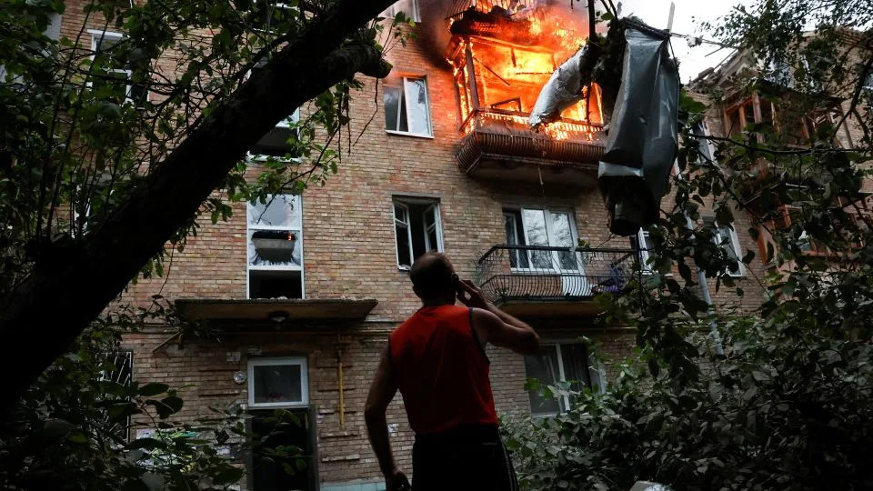 A resident looks on at the site of an apartment building hit during Russian missile and drone strikes in Kyiv, Ukraine, on July 31. - Thomas Peter/Reuters