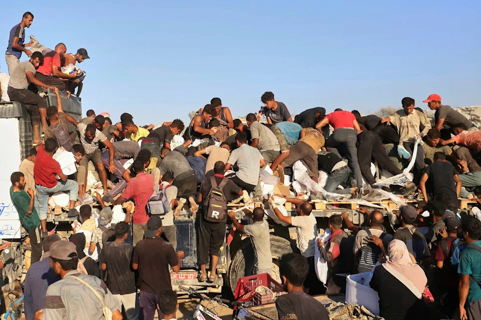 Mariam Dagga/AP - PHOTO: Palestinians struggle to get food and humanitarian aid from the back of a truck as it moves along the Morag corridor near Rafah, in the southern Gaza Strip, Aug. 4, 2025.