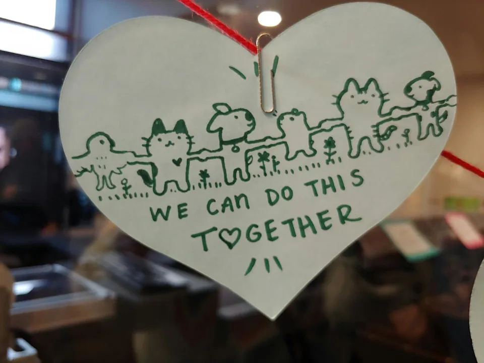 A wooden heart with green text and animated animals reads: