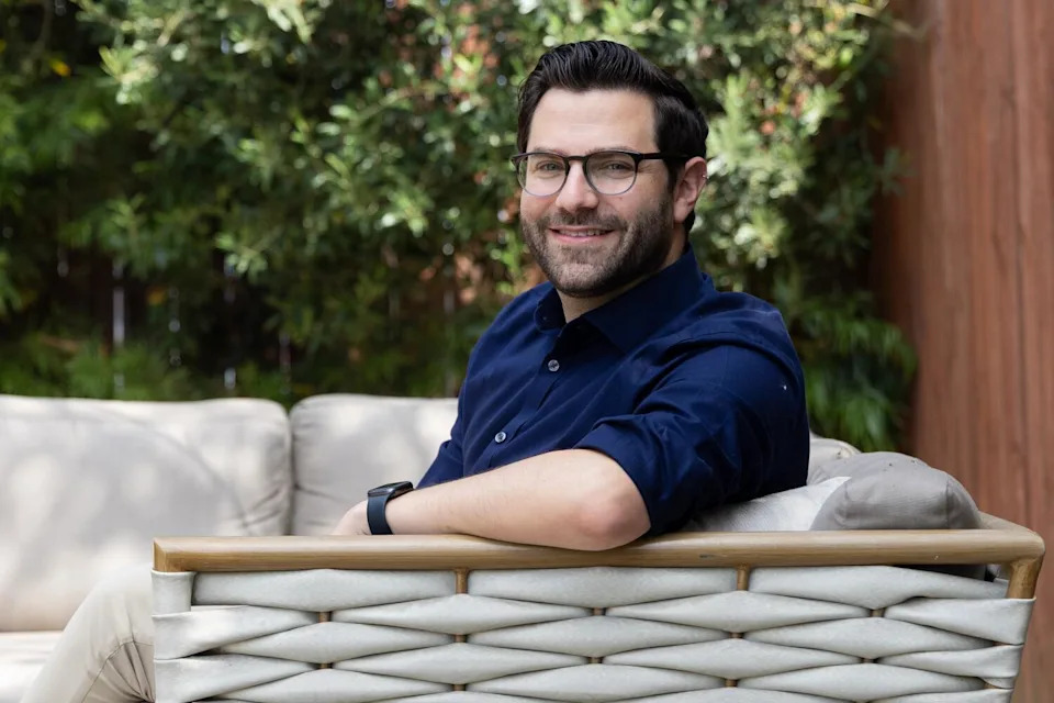 A man in an outdoor sofa.