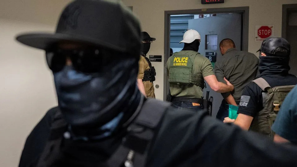 A migrant is detained and escorted July 17 by masked federal immigration officers at a US immigration court in New York. - David Dee Delgado/Reuters