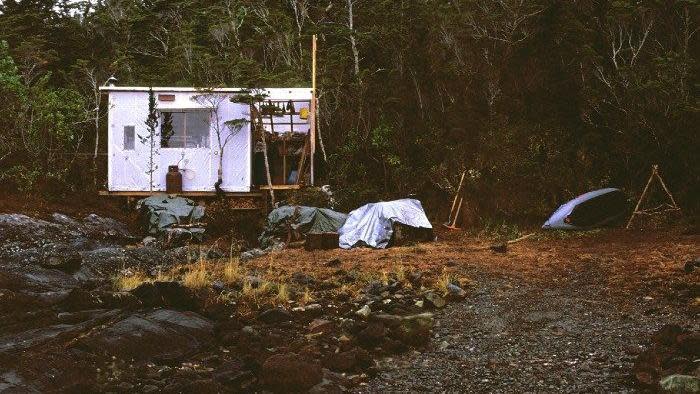 cabaña de bob kull en la patagonia construida con madera contrachapada y lonas de plástico sobre unos pilares