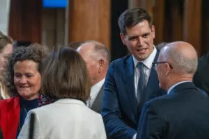  State Sen. John Fredrickson of Omaha, center, greets Speaker John Arch of La Vista on the final day of the 2025 legislative session. June 2, 2025. (Zach Wendling/Nebraska Examiner)