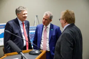 North Dakota Petroleum Council President Ron Ness, left, talks to North Dakota Gov. Kelly Armstrong, center, and North Dakota State University researcher Dean Bangsund during a March 2025 event to highlight the economic impact of the oil and gas industry. (Kyle Martin for North Dakota Monitor)
