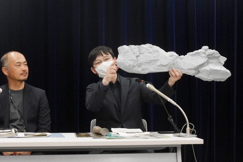 サッポロクジラの化石のレプリカを手に解説する田中嘉寛・札幌市博物館活動センター学芸員（右）＝札幌市中央区で2025年8月26日午後4時26分、水戸健一撮影