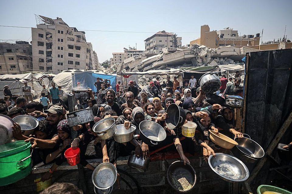 Un grupo de niñas y mujeres con sus platos a la espera de comida en Gaza