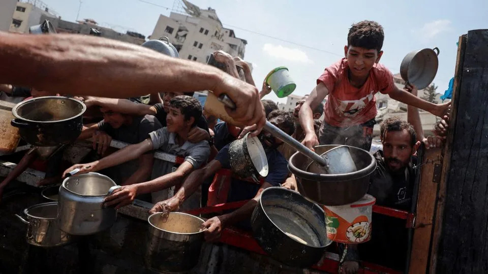 Palestinians gather to receive food from a charity kitchen amid a hunger crisis in Gaza City on Monday. - Khamis Al-Rifi/Reuters