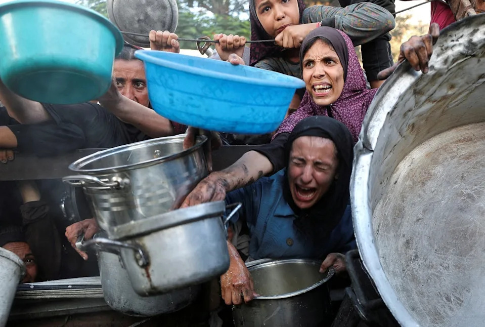 Palestinians ask for food from a charity kitchen, amid a hunger crisis, in Gaza City (REUTERS)
