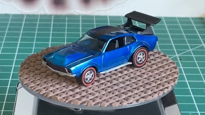 A rose-colored 1970 Hot Wheels Mighty Maverick on a white surface.