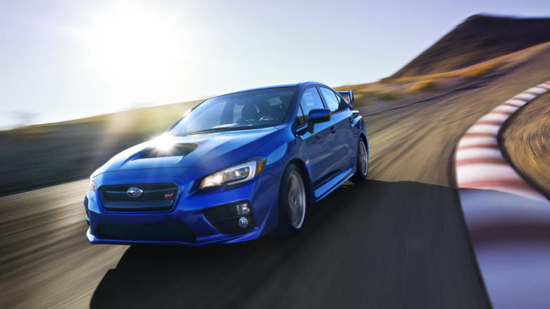 A blue 2015 Subaru WRX STi driving around a track