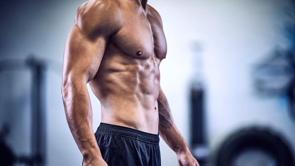 A photo of a man in the gym with strong abs.
