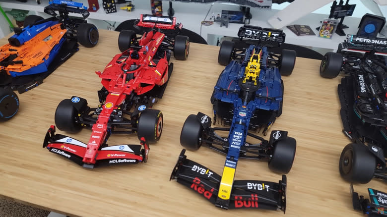 The four Lego Technic F1 car model sets, including the orange McLaren, red Ferrari, blue Red Bull, and black Mercedes-AMG