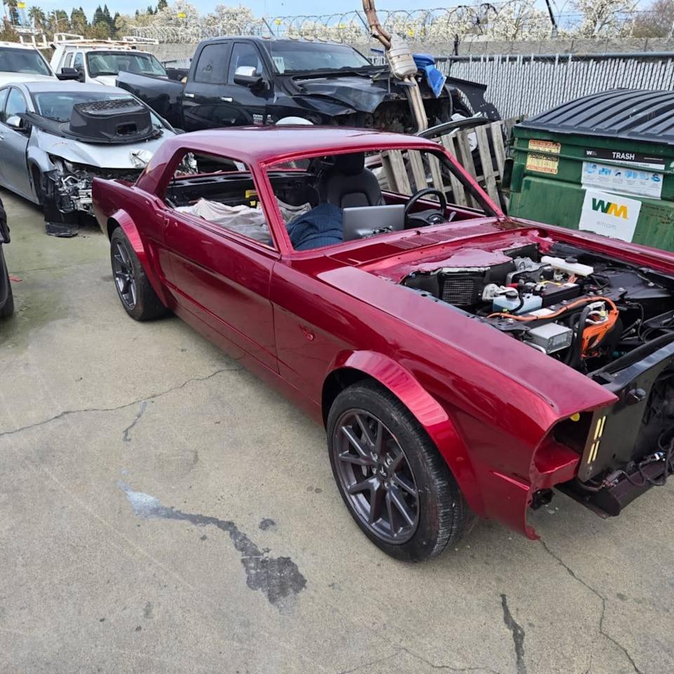 a modified vintage car in a junkyard setting