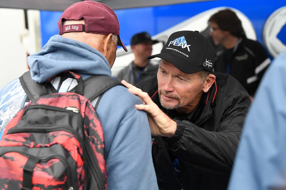 a conversation between two individuals one wearing a cap and the other a hoodie with a backpack