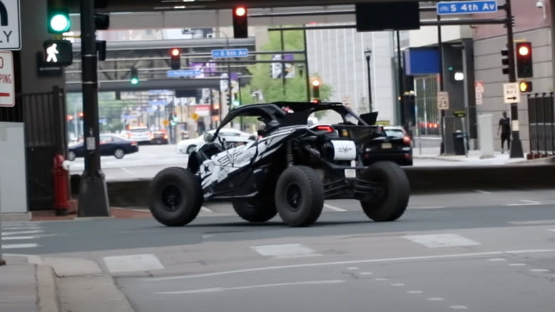 A white and black side-by-side driving on city streets.
