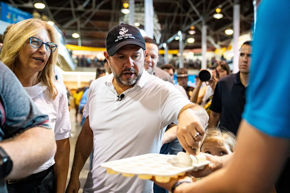 U.S. Sen. Ruben Gallego, D-Arizona, grabs an egg on a stick during the second day of the Iowa State Fair on Aug. 8, 2025, in Des Moines, Iowa.